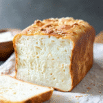 Homemade gluten free almond flour bread with rosemary on a wooden cutting board