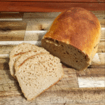 Sliced homemade kamut bread on a rustic wooden board