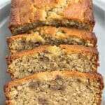 Moist keto banana bread loaf sliced on a wooden board