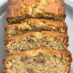 Moist keto banana bread loaf sliced on a wooden board